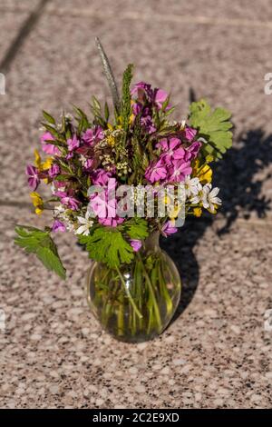 Farbenprächtiger Frühlingsstrauß aus dem Garten in der Hand gehalten und in den Himmel gestreckt Stockfoto
