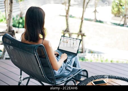 Junge schöne Frau arbeitet auf Laptop im Freien Stockfoto