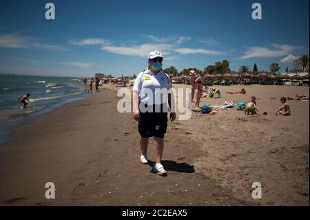 Malaga, Spanien. Juni 2020. Eine Strandhilfe mit Gesichtsmaske geht an einem sonnigen Tag am Strand von Misericordia entlang, während die Einschränkungen durch den Ausbruch von COVID-19 gelockert werden.die meisten Städte in Spanien befinden sich in Phase drei, in der Menschen in andere Provinzen derselben autonomen Gemeinschaft ziehen und gehen. Die spanische Regierung sagt, dass der Ausnahmezustand am 21. Juni nach drei Monaten Sperrung enden wird und dann eine "neue Normalität" beginnen wird, nach Gesundheits- und Sicherheitsmaßnahmen, bis ein Impfstoff vorliegt. Kredit: SOPA Images Limited/Alamy Live Nachrichten Stockfoto