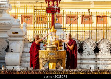 Buddhistische Mönche gießen Wasser über EINE Buddha Statue in der Shwedagon Pagode, Yangon, Myanmar. Stockfoto