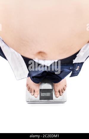 Blick von oben auf ein junger Mann mit großen Magen und gewichtsprobleme stehen auf einer Skala, die auf weißem Hintergrund. Stockfoto