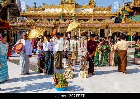 Eine burmesische Familie nimmt an EINER Noviziation/Shinbyu Zeremonie in der Shwedagon Pagode, Yangon, Myanmar Teil. Stockfoto