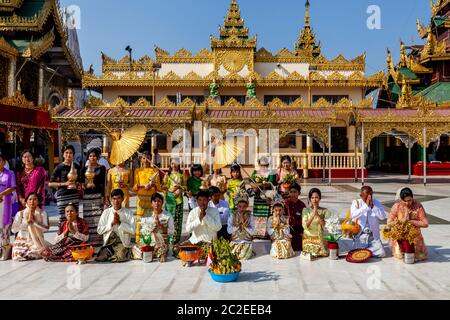 Eine Familie betet bei EINER Noviziation/Shinbyu Zeremonie in der Shwedagon Pagode, Yangon, Myanmar. Stockfoto