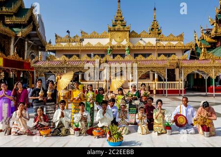 Eine Familie betet bei EINER Noviziation/Shinbyu Zeremonie in der Shwedagon Pagode, Yangon, Myanmar. Stockfoto