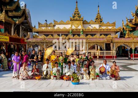 Eine Familie betet bei EINER Noviziation/Shinbyu Zeremonie in der Shwedagon Pagode, Yangon, Myanmar. Stockfoto