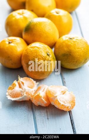 Frische Mandarinen gelb auf blau Holztisch. Stockfoto