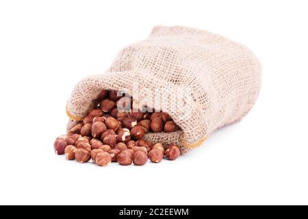 Verschüttete Sackleinen sack Haselnüsse, auf weißem Hintergrund. Stockfoto