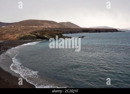 Strand mit schwarzem Sand in der Nähe von felsigen Küste in Ajuy Dorf, Fuerteventura, Spanien. Stockfoto