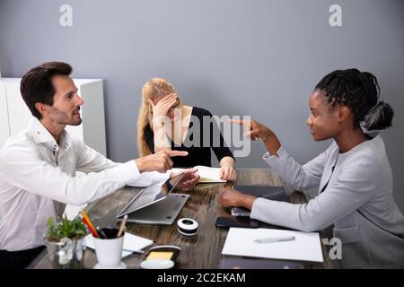 Geschäftsleute, die sich gegenseitig die Schuld beim Besprechen mit Ihren Kollegen in der Konferenz Stockfoto
