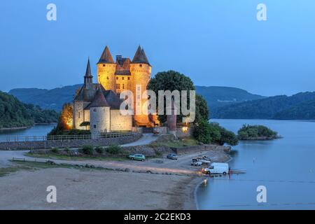 Chateau de Val in Auvergne, Frankreich bei Dämmerung mit Blick auf den künstlichen See, der ihn umgibt. Stockfoto