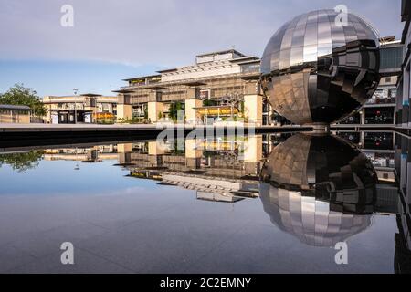 Das markante Spiegelkugelplanetarium des We the Curious Museums spiegelt sich in einem Pool am Millennium Square auf der Harbourside von Bristol wider. Stockfoto