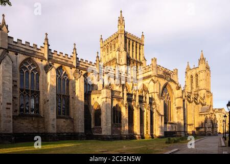 Das Licht der Morgenröte fällt auf die gotische Fassade der Bristol Cathedral neben dem College Green. Stockfoto