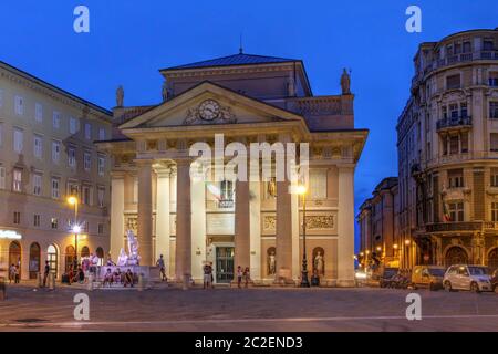 Nachtaufnahme auf dem Platz der Börse in der Innenstadt von Triest, Italien, mit Fokus auf dem alten neoklassizistischen Gebäude der Börse. Stockfoto