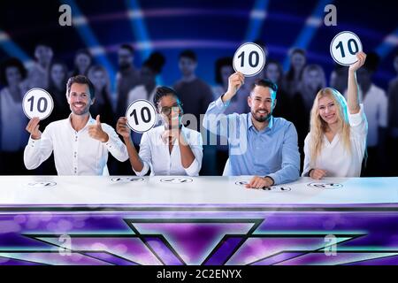 Happy Panel Richter Vor der rote Vorhang mit 10 Score Zeichen Sitzen Stockfoto