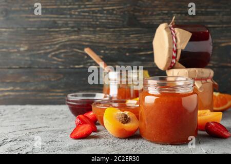 Komposition mit Marmelade und Zutaten auf grauem Tisch, Platz für Text Stockfoto