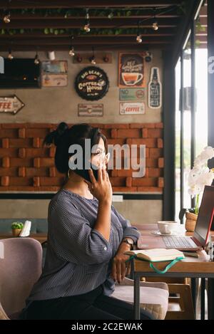 Frau am Telefon reden, arbeiten und Kaffee trinken Stockfoto