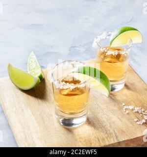 Golden tequila Schüsse mit Kalk und Salz, mit Kopie Raum, quadratischen Bild Stockfoto