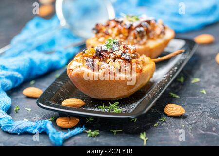 Gebackene Birne mit Rosinen, Nüssen und Honig. Stockfoto