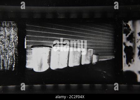 Feine 70er Jahre Vintage Kontakt Print schwarz-weiß extreme Fotografie einer Reihe von gespenstischen glühenden Abfalleimer in der Hintergasse aufgereiht. Stockfoto