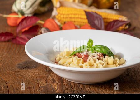 Nudeln mit Tomatensoße auf dunklem Holz Stockfoto