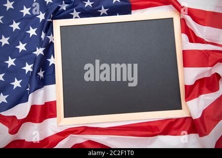 Stoff USA Flagge und schwarze Tafel oder Kreidetafel auf der Oberseite mit Platz für Text, Draufsicht Stockfoto