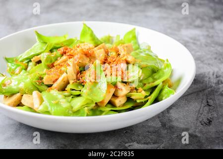 Rühren Sie die Schneeerbsen mit vietnamesischen gegrillten Schweinefleisch Wurst, Belag mit knusprig gebratenen Schalotten und Garl Stockfoto