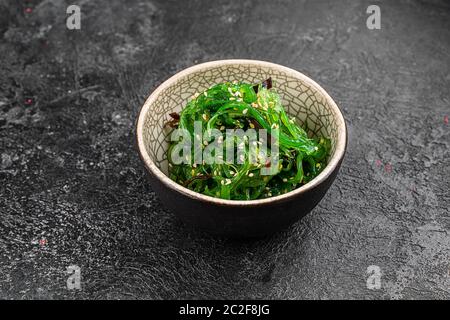 Algen Salat auf schwarzem Teller. Chuka wakame Auf dem alten Hintergrund. Draufsicht. Freier Speicherplatz für Ihren Text. Stockfoto