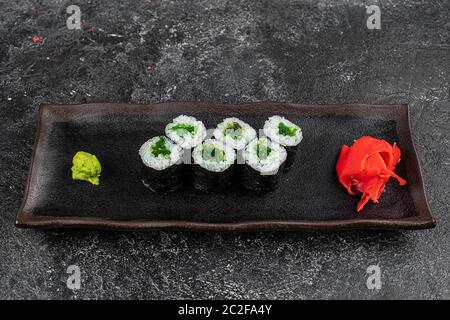 Sushi-Brötchen mit Meeresfrüchten und Chuka-Salat. Grünes Sushi. Draufsicht. Freier Speicherplatz für Ihren Text. Stockfoto