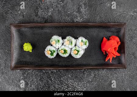 Sushi-Brötchen mit Meeresfrüchten und Chuka-Salat. Grünes Sushi. Draufsicht. Freier Speicherplatz für Ihren Text. Stockfoto