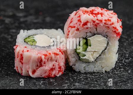 Japanische Küche Sushi-Brötchen California mit Frischkäse und Masago Kaviar auf dunklem Hintergrund Stockfoto