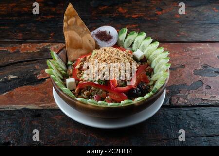 Türkischer Gavurdagi-Salat. Walnusssalat mit Gemüse auf rustikalem Holztisch Stockfoto