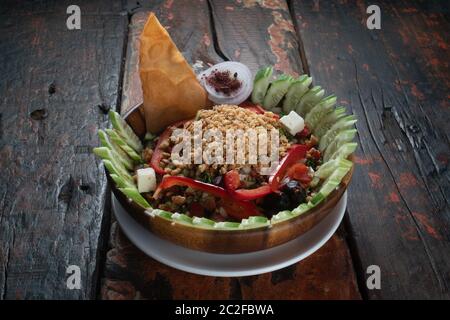 Türkischer Gavurdagi-Salat. Walnusssalat mit Gemüse auf rustikalem Holztisch Stockfoto