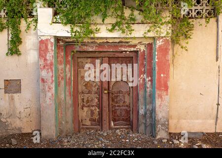Traditionelle alte rötlich-braune Holztür in der Stadt Al Ayjah in der Nähe von Sur, Oman Stockfoto