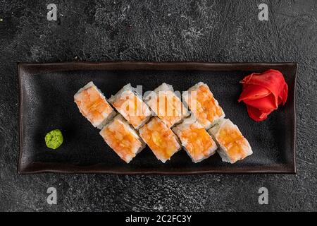 japan Sushi-Rollen mit Lachs, Garnelen und geräuchertem Aal mit Frischkäse auf schwarzer Platte Stockfoto