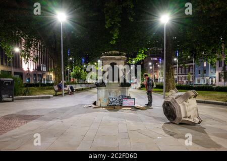 Bristol, England, Großbritannien - 8. Juni 2020: Menschen, die am Sockel der gestürzten Statue des Sklavenhändlers Edward Colston in Bristol vorbeikommen, lesen und hinterlassen Plakate Stockfoto