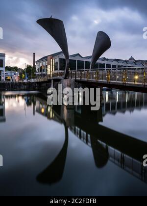 Bristol, England, Großbritannien - 8. Juni 2020: Die Sonne geht über den Transit Shed Lagerhallen von Bristol's postindustriellem Harbourside und dem modernen Pero's Römerhaus unter Stockfoto