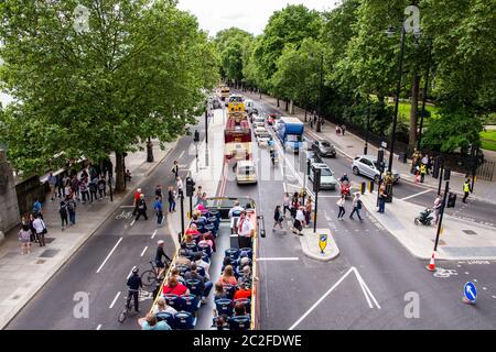 Fußgänger überqueren das Embankment, während ein Reisebus und andere Verkehrsverbindungen warten, in Westminster im Zentrum von London. Stockfoto