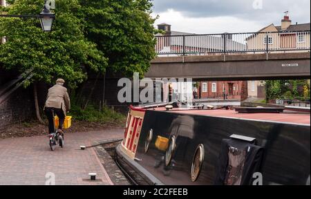 Birmingham, England, Großbritannien - 23. Juni 2012: Ein Radfahrer fährt ein Brompton Faltfahrrad auf einem Abschleppweg des Birmingham und Fazeley Kanals im Zentrum von Birmin Stockfoto