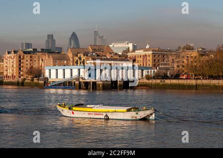 London, England, UK - 16. November 2010: Wintersonne scheint auf Wappings Metropolitan Police Boatyard Pier und alten Lagerhäusern, die in Wohnungen umgewandelt wurden Stockfoto