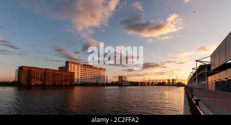 London, England, Großbritannien - 31. Juli 2010: Der Sonnenuntergang wirft einen Schein über die Millennium Mills und Excel Gebäude am Royal Victoria Dock im Osten Londons Stockfoto