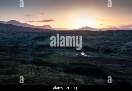 Die Sonne geht über den Black Mount Bergen und der Torfmoorlandschaft von Rannoch Moor in den West Highlands von Schottland unter. Stockfoto