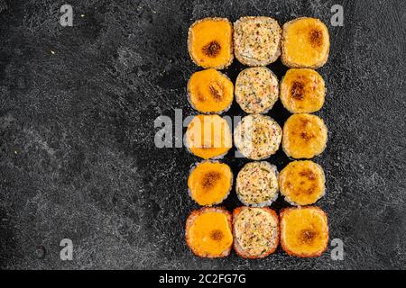Gebackene Sushi-Brötchen mit Wasabi und Ingwer auf schwarzem Hintergrund. Japanische orientalische Küche Stockfoto