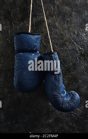 Alte blaue Boxhandschuhe an der Wand hängen Stockfoto