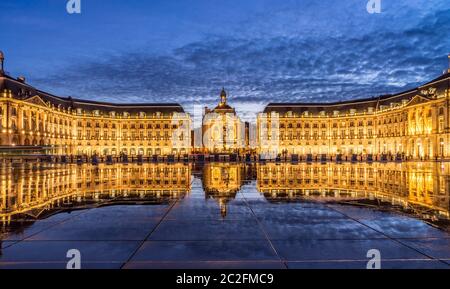 Kultige Panorama der Place De La Bourse mit Straßenbahn und Wasser Spiegel Brunnen in Bordeaux - Frankreich, Gironde Stockfoto