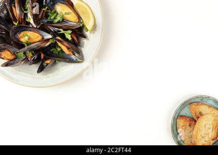 Marinara-Muscheln, Moules Mariniere, von oben auf weißem Hintergrund mit geröstetem Brot und Kopierraum, belgisches Essen desi Stockfoto