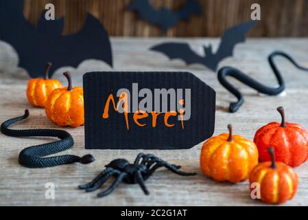 Black Label mit französischen Text Merci bedeutet. Vielen Dank. Scary Halloween Dekoration wie Bat, Schlange und Spider Stockfoto