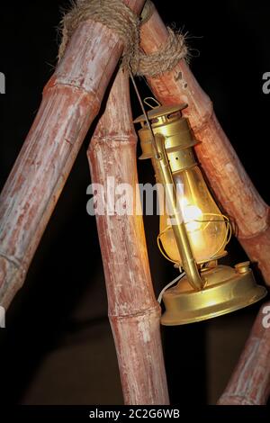 Eine Petroleumlampe, die an Bambusstäben befestigt ist Stockfoto