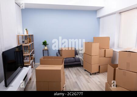 Stapel von Braun Umzug Kartons auf Parkett im Wohnzimmer sind Stockfoto