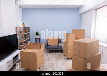 Stapel von Braun Umzug Kartons auf Parkett im Wohnzimmer sind Stockfoto