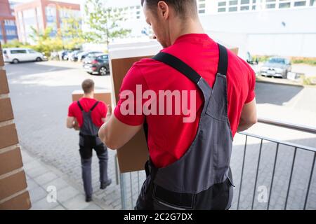 Rückansicht eines Männer laden die braunen Kartons in den Umzugs-LKW Stockfoto